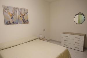 a bedroom with a bed and a dresser and a mirror at Flamingo view in Quartu SantʼElena