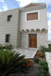 Skinari Apartments في Monolia: منزل أبيض مع باب خشبي