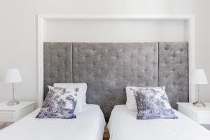 Un dormitorio con dos camas y dos mesitas de noche. en Lisbon Center V, en Lisboa