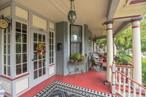 a porch of a house with a red deck at The Inn on Holly B&B in Pitman