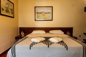 ein Schlafzimmer mit einem Bett mit zwei Kissen darauf in der Unterkunft Hotel Marina Porto Abrolhos in Caravelas