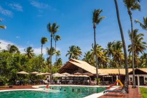 a pool at a resort with palm trees and a slide at Vivant Eco Beach OFICIAL in Barra Grande