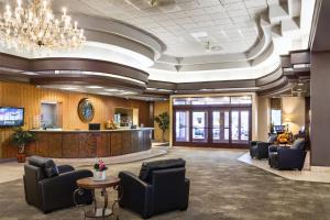 a lobby with a waiting area with chairs and a counter at Grand Hotel in Minot