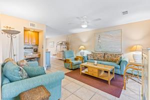 a living room with two blue couches and a table at Gulf Winds #50 in Destin