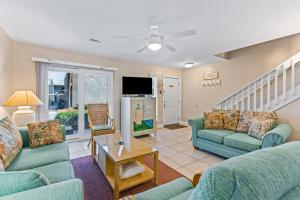 a living room with two couches and a tv at Gulf Winds #50 in Destin