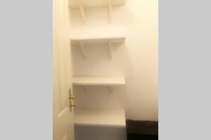 a white closet with white shelves and a door at Gemütliche sanierte 1 Zimmer Wohnung mit privatem Parkplatz im Zentrum in Kiel +14 photos