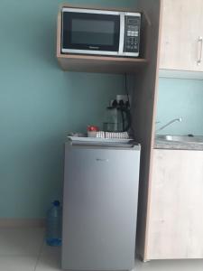 a microwave on top of a refrigerator in a kitchen at Masane Lodge in Rustenburg