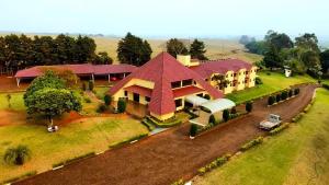 une vue aérienne sur une grande maison sur un champ dans l'établissement Colinas Executive Park Hotel, à Giruá