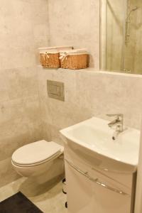 Baño blanco con aseo y lavamanos en Apartament Studio Klasztorna en Dzierżoniów