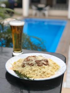 a plate of pasta on a table with a glass of beer at Hotel Boulevard in Lima