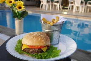 a hamburger and fries on a plate next to a pool at Hotel Boulevard in Lima