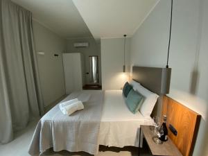 Un dormitorio con una gran cama blanca y una mesa en Villa Antonino, en Giardini Naxos