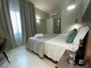 a hotel room with a bed and a table with wine glasses at Villa Antonino in Giardini Naxos