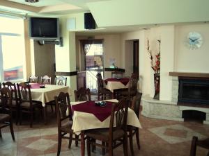 comedor con mesas y sillas y chimenea en Family Hotel Daisy, en Borino