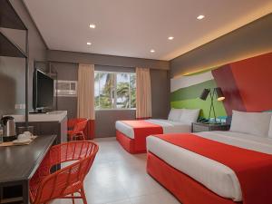a hotel room with two beds and a desk at Boracay Uptown in Boracay