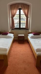 2 Betten in einem Zimmer mit Fenster in der Unterkunft HOTEL CHATEAU ZAMEK CEJKOVICE in Čejkovice