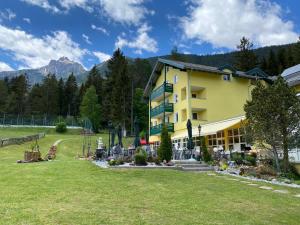a large yellow building with a lawn in front of it at Hotel Belmont in Imst