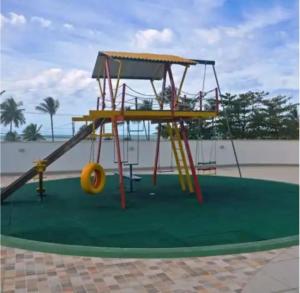 un parco giochi con uno scivolo di fronte alla spiaggia di Apartamento em frente ao mar em Ilhéus, na Praia do Sul a Ilhéus