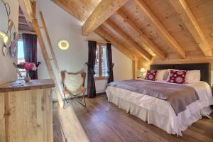 ヴィラール・シュル・オロンにあるBalthazar The Loft by Villars Luxuryの木製の天井が特徴のベッドルーム1室(ベッド1台付)