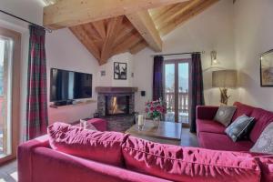 a living room with a red couch and a fireplace at Balthazar The Loft by Villars Luxury in Villars-sur-Ollon