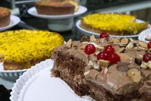un morceau de gâteau au chocolat avec des cerises sur une table dans l'établissement Tezla Hotel, à Primavera do Leste