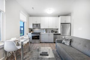 a living room with a couch and a table and a kitchen at Global Luxury Suites East Boston in Boston