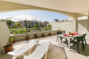 a balcony with a table and chairs and an umbrella at Apartamento San Remo Soleado in Palm-Mar