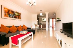 a living room with a couch and a tv at Apartamento San Remo Soleado in Palm-Mar