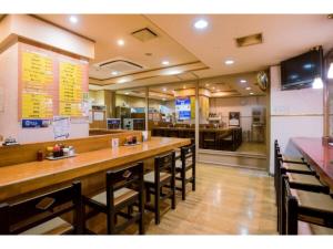 un ristorante con un lungo bar e alcune sedie di Hotel Taisei Annex - Vacation STAY 05189v a Kagoshima