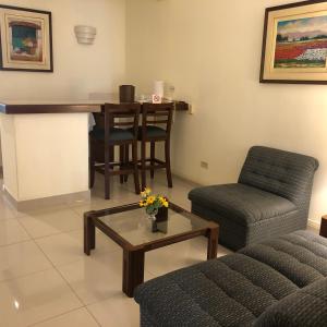 a living room with a couch and a table and a chair at Hotel Boulevard in Lima