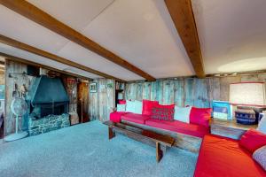- un salon avec un canapé rouge et une cheminée dans l'établissement The Tupfe Cabin, à Franconia