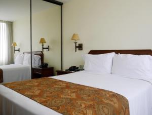 a hotel room with two beds and a mirror at Hotel Boulevard in Lima