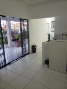 an empty room with a sliding glass door with a hammock at Pousada alojacampinas in Viracopos