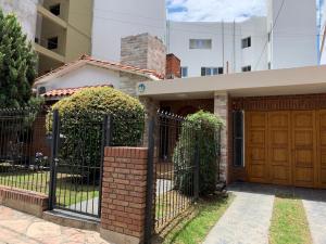 a house with a gate and a building at Ganesha in Villa Carlos Paz