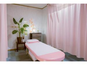 a hospital room with a pink bed and a curtain at Hotel Taisei Annex - Vacation STAY 05217v in Kagoshima
