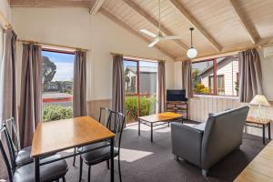 un soggiorno con tavoli, sedie e finestre di Discovery Parks - Melbourne a Braybrook