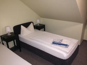 ein Schlafzimmer mit einem Bett und zwei Tischen mit Lampen in der Unterkunft Hotel Gasthof am Waldeck in Oberthulba