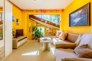 uma sala de estar com paredes amarelas e um sofá em Apartments SENKA em Dramalj
