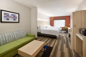 Holiday Inn Express Hotel & Suites Salem, an IHG Hotel في سالم: غرفة في الفندق مع أريكة وسرير