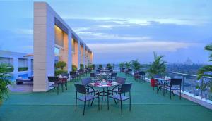 a restaurant on the roof of a building with tables and chairs at Radisson Hotel Agra in Agra