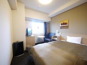 Habitación de hotel con cama y TV en Hotel Route-Inn Sendai Taiwa Inter, en Taiwa