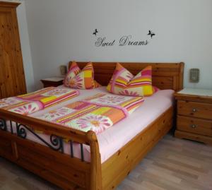 un letto in legno con cuscini sopra di Ferienwohnung Andrea a Riedenburg