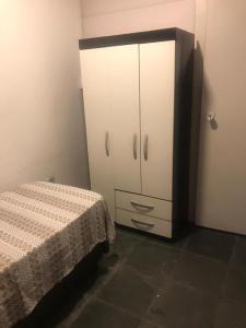 um quarto com uma cama e um armário branco em Pousada Fran em São Paulo