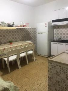 a kitchen with a table and a refrigerator at Pousada Fran in Sao Paulo