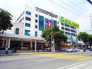 a large building on a city street with cars in front at Go Hotels Otis - Manila in Manila