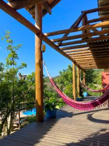 a hammock hanging from a wooden pergola at Pueblo Rosa Norte in Praia do Rosa