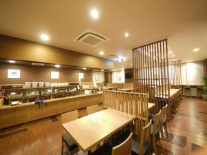 un restaurante con mesas de madera, sillas y encimeras en Hotel Route-Inn Sendai Taiwa Inter, en Taiwa