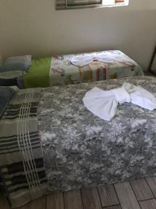 Una cama con sábanas sucias y toallas. en Pousada Vera, en São Paulo