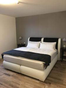 a bedroom with a large white bed in a room at Hotel Schwarzes Ross in Ganderkesee