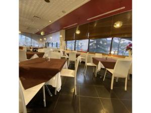 a restaurant with wooden tables and white chairs at Shobara Grand Hotel - Vacation STAY 06902v in Shōbara